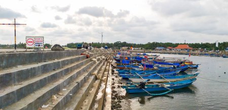 Foto de Bandung, Indonesia-15 de marzo de 2020; El ambiente en un puerto de playa de Pangandaran, donde muchos barcos de pesca están estacionados en la playa - Imagen libre de derechos