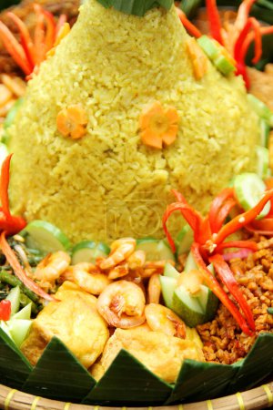 Foto de Guarniciones de Nasi Tumpeng, como camarones fritos, tempeh seco, tofu frito, verduras y chile rojo para ornamental - Imagen libre de derechos