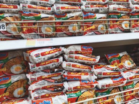 Téléchargez les photos : Bandung, Indonésie - 27 mars 2024 ; Des paquets de nouilles instantanées Indomie Mie Goreng (nouilles frites) sont disposés sur les étagères d'une épicerie ou d'un supermarché - en image libre de droit