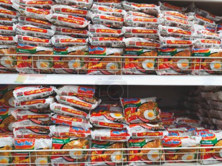 Téléchargez les photos : Bandung, Indonésie - 27 mars 2024 ; Des paquets de nouilles instantanées Indomie Mie Goreng (nouilles frites) sont disposés sur les étagères d'une épicerie ou d'un supermarché - en image libre de droit