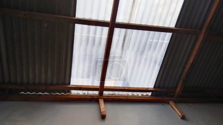 Helle Nachmittagssonne dringt durch das Dach des Hauses mit Asbestmaterial und wellenförmigem UV-Kunststoff ein