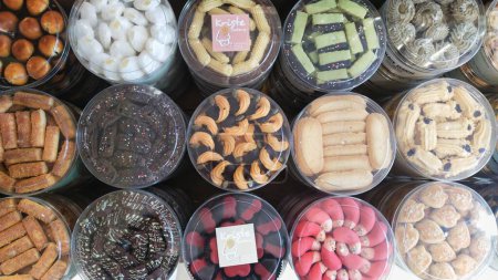 Foto de Bandung, Indonesia - 3 de abril de 2024; Una variedad de atractivos colores, formas y sabores de pasteles secos envasados en frascos para dar la bienvenida a Eid al-Fitr - Imagen libre de derechos