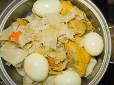 Blick von oben auf das hausgemachte "Bakso tahu" -Menü bestehend aus Knödeln, gekochten Eiern, gebratenem Tofu und weißem Tofu im Dampfgarer