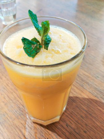 glass of fresh sun kist orange juice on wooden table