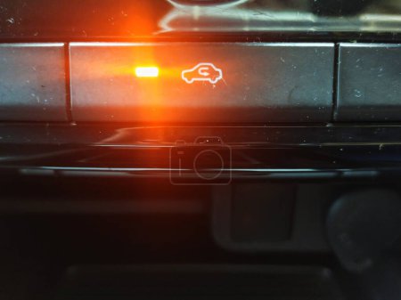 close up of the recirculation button with the indicator light on to indicate it is activated, in the interior of a car