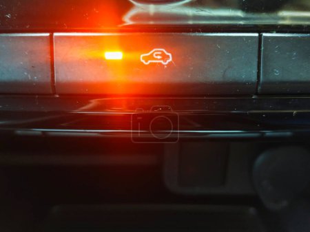 Nahaufnahme der Umwälztaste mit eingeschaltetem Kontrolllicht, um anzuzeigen, dass sie aktiviert ist, im Innenraum eines Autos