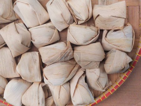 snack dulce llamado Wajit por encima de bambú tejido. El wajit es un alimento típico envuelto en hojas de maíz hechas de arroz pegajoso, azúcar blanca, azúcar morena y coco.