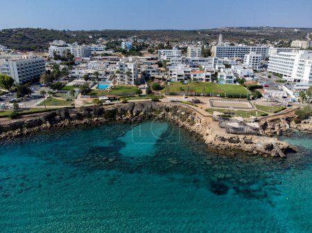 Vista panorámica aérea de villas y resorts de vacaciones y aguas cristalinas azules en el mar Mediterráneo cerca de la playa de higuera de arena, Protaras, Chipre