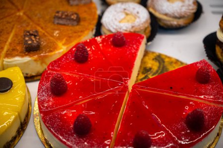 Assortment of french fresh baked sweet pastry with fresh fruits and berries in confectionery shop close up