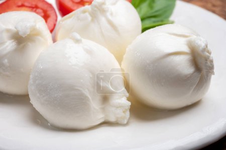 Foto de Comida de queso italiano suave fresco hecho a mano de Puglia, bolas blancas de burrata o queso burratina hecho de mozzarella y relleno de crema de cerca - Imagen libre de derechos