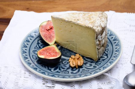 Photo for Pieces of cheese tomme de montagne or tomme de savoie made from cow milk in French Alps. served with fresh figs - Royalty Free Image