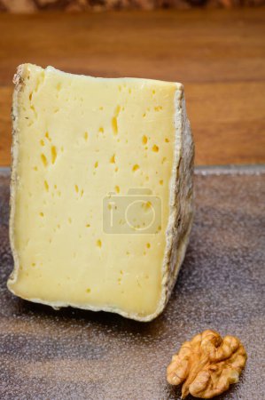 Photo for Pieces of cheese Tomme de montagne or tomme de savoie made from cow milk in French Alps - Royalty Free Image