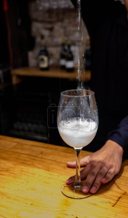 Photo for Pouring of txakoli or chacol slightly sparkling very dry white wine produced in Spanish Basque Country in typical bar in old part of San Sebastian or Donostia, Spain - Royalty Free Image