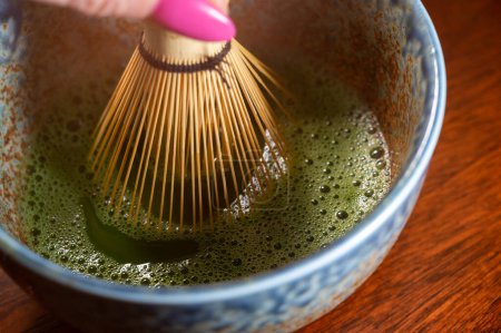 Photo for Preparation of green Matcha tea from finely ground powder of specially grown and processed green tea leaves consumed in East Asia and Japan. - Royalty Free Image