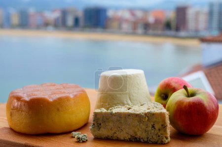 Téléchargez les photos : Fromages asturiens, fromage de vache fumé de Pria, cabralis au fromage bleu d'Arenas et rebollin blanc de Pitu, Asturies, servis en plein air avec vue sur la plage de San Lorenzo à Gijon, Espagne - en image libre de droit
