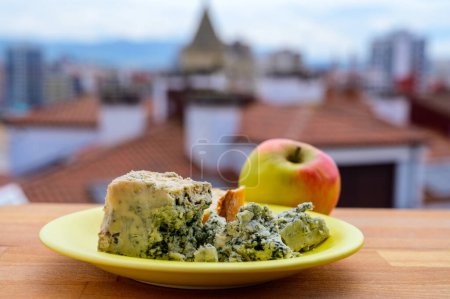 Téléchargez les photos : Cabrales de vache bleue fromage d'Arenas servi en plein air avec vue sur la plage de San Lorenzo et les maisons d'iGijon - en image libre de droit