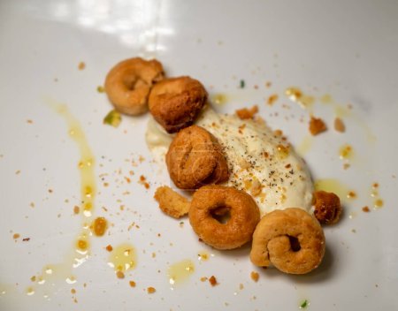 Foto de Pan italiano de taralli servido con crema de queso ricotta fresca. Comida italiana servida en el restaurante, de cerca - Imagen libre de derechos