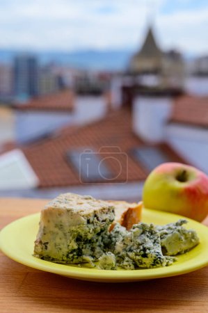 Téléchargez les photos : Cabrales de vache bleue fromage d'Arenas servi en plein air avec vue sur la plage de San Lorenzo et les maisons d'iGijon - en image libre de droit