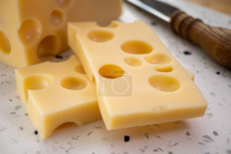 Photo for Cheese collection, block of french hard cheese with holes emmentaler close up - Royalty Free Image