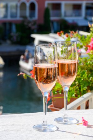 Fiesta de verano, beber vino espumoso de champán rosa brut francés en copas en el puerto deportivo de Port Grimaud cerca de Saint-Tropez, vacaciones Riviera francesa, Var, Francia