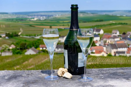 Dégustation de vin blanc mousseux grand cru avec champagne bulles avec vue d'été sur maisons et vignobles Grand cru petit village producteur Cramant, Champagne, France