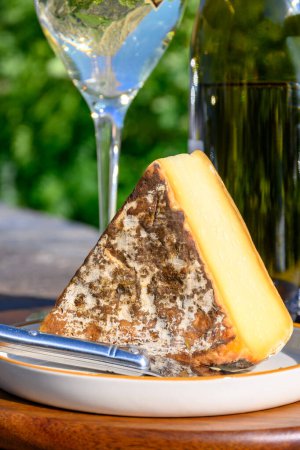 Téléchargez les photos : Fromage et vin, verres de vin blanc sec Roussette de Savoie et Vin de Savoie de Savoie avec tomme et vue sur les Hautes Alpes avec neige au sommet en été. - en image libre de droit