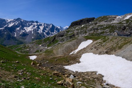Foto de Carretera de montañas estrechas de Col de Lautaret a Col du Calibier, Montañas y prados alpinos verdes vistas del macizo de los Ecrins, Hautes Alpes, Francia en verano - Imagen libre de derechos