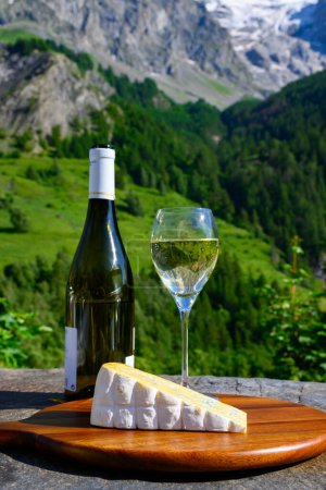 Téléchargez les photos : Fromage et vin, verres de vin blanc sec Roussette de Savoie et Vin de Savoie de la région savoyarde au fromage bleu et vue sur les Hautes Alpes avec neige au sommet - en image libre de droit