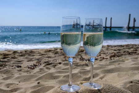 Sommerzeit in der Provence, zwei Gläser kalten Champagner cremant Sekt am berühmten Sandstrand von Pampelonne in der Nähe von Saint-Tropez bei sonnigem Tag, Departement Var, Verschwinden in Frankreich