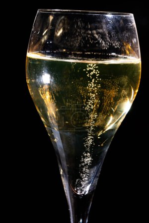 Photo for Glass of french sparkling champagne wine with bubbles on dark background, golden bubbles close up - Royalty Free Image