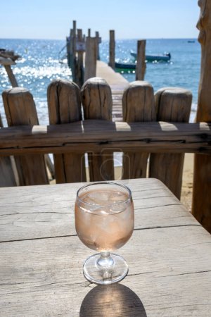 Téléchargez les photos : Fête d'été en Provence, verre de vin rose avec glaçons sur bar terrasse Plage de sable de Pampelonne près de Saint-Tropez par temps ensoleillé, département du Var, France - en image libre de droit