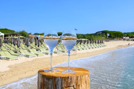 Téléchargez les photos : Heure d'été en Provence, deux verres de vin rose froid sur la plage de sable de Pampelonne près de Saint-Tropez par temps ensoleillé, département du Var, France. - en image libre de droit