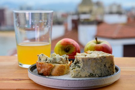 Speiseempfehlung in Asturien, blauer Kuhcabrales-Käse aus Höhlen in Arenas, serviert im Freien mit einem Glas natürlichem Apfelmost und Blick auf den Strand San Lorenzo in Gijon, Spanien