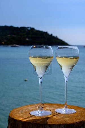 Téléchargez les photos : Heure d'été en Provence, deux verres de champagne froid crémant mousseux sur la célèbre plage de sable de Pampelonne près de Saint-Tropez par temps ensoleillé, département du Var, vanation en France - en image libre de droit