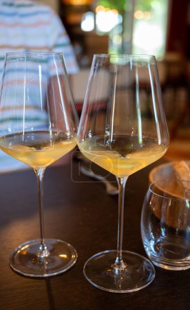 Foto de Degustación de vino blanco de Burdeos en Sauternes, orilla izquierda del estuario de Gironda, Francia. Vasos de vino francés dulce blanco servidos en el restaurante - Imagen libre de derechos