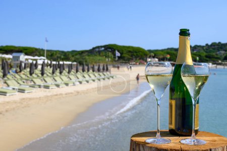 Téléchargez les photos : Heure d'été en Provence, deux verres de champagne froid crémant mousseux sur la célèbre plage de sable de Pampelonne près de Saint-Tropez par temps ensoleillé, département du Var, vanation en France - en image libre de droit