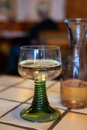 Foto de Vino riesling de calidad blanca servido en copa de vino verde remolino en el antiguo restaurante alemán en el pueblo de Monschau, Alemania de cerca - Imagen libre de derechos