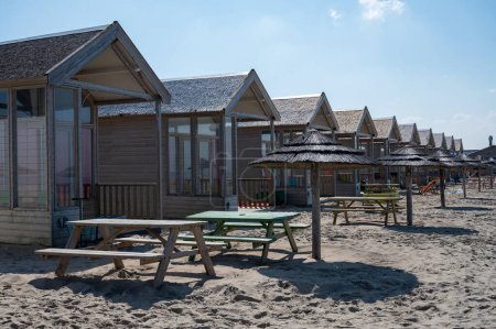 Téléchargez les photos : Vacances à la plage et loisirs sur la plage de sable, chalets en bois en bord de mer à Katwijk-on-zee, Mer du Nord, Pays-Bas - en image libre de droit