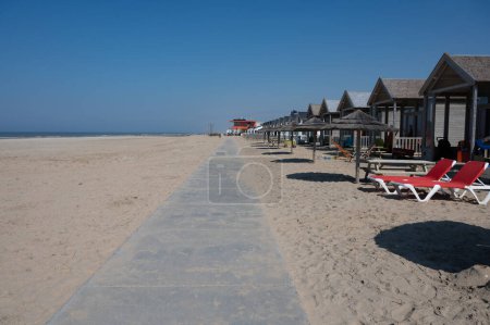 Téléchargez les photos : Vacances à la plage et loisirs sur la plage de sable, chalets en bois en bord de mer à Katwijk-on-zee, Mer du Nord, Pays-Bas - en image libre de droit
