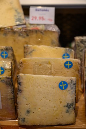 Foto de Gamoneu o queso gamonedo elaborado con leche de vaca, oveja y cabra ligeramente ahumada con cáscara fina y natural de Asturias a la venta en tienda, España - Imagen libre de derechos