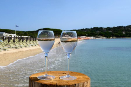 Téléchargez les photos : Heure d'été en Provence, deux verres de vin rose froid sur la plage de sable de Pampelonne près de Saint-Tropez par temps ensoleillé, département du Var, France. - en image libre de droit