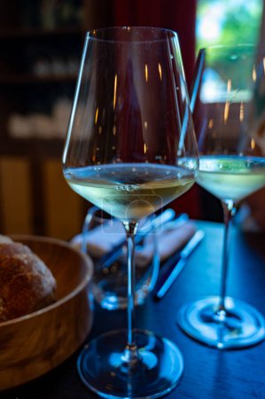 Téléchargez les photos : Dégustation de vin blanc de Bordeaux à Sauternes, rive gauche de l'estuaire de la Gironde, France. Verres de vin blanc doux français servis au restaurant - en image libre de droit