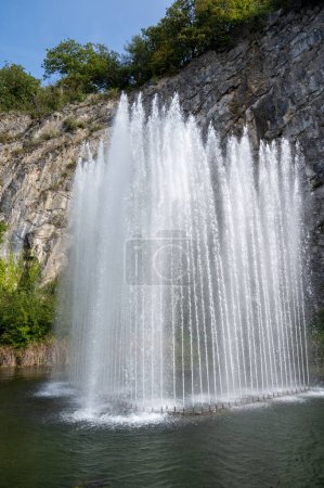Téléchargez les photos : Grande fontaine rocheuse, marche dans la plus petite ville médiévale du monde Durbuy sur la rivière Ourthe, Ardennen, Belgique par temps ensoleillé - en image libre de droit