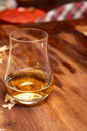 Foto de Degustación de diferentes whiskies escoceses fuertes bebidas alcohólicas, vaso de whisky y colorido tartán escocés en primer plano - Imagen libre de derechos