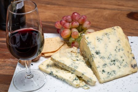 Photo for Red porto and cheese pairing, blue matured stilton English cheese served as dessert with walnuts and glass ruby porto wine close up - Royalty Free Image