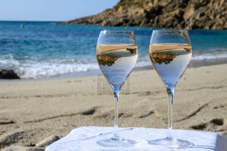 Téléchargez les photos : Heure d'été en Provence, deux verres de vin de rose froid sur une plage de sable fin près de Saint-Tropez par temps ensoleillé, département du Var, France. - en image libre de droit
