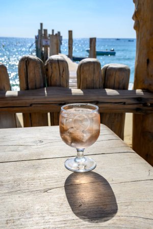 Téléchargez les photos : Fête d'été en Provence, verre de vin rose avec glaçons sur bar terrasse Plage de sable de Pampelonne près de Saint-Tropez par temps ensoleillé, département du Var, France - en image libre de droit