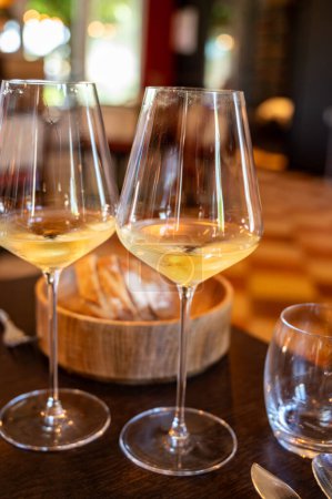 Foto de Degustación de vino blanco de Burdeos en Sauternes, orilla izquierda del estuario de Gironda, Francia. Vasos de vino francés dulce blanco servidos en el restaurante - Imagen libre de derechos