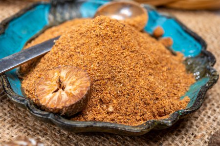 Photo for Tasty winter spice whole dried and ground powder nutmeg, used as an ingredient in many dishes, eggnog, potato, mulled wine, close up - Royalty Free Image