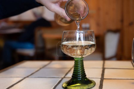 Foto de Vino riesling de calidad blanca servido en copa de vino verde remolino en el antiguo restaurante alemán en el pueblo de Monschau, Alemania de cerca - Imagen libre de derechos